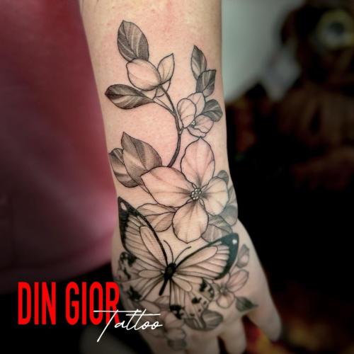 татуировка цветка с бабочкой на цветке в стиле реализм в стиле 