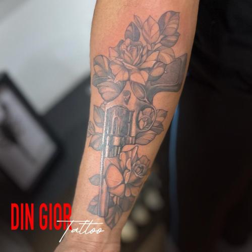 татуировка пистолета с розами в стиле реализма