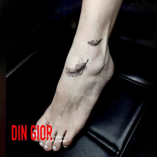 татуювання пера на ноге чоловіка